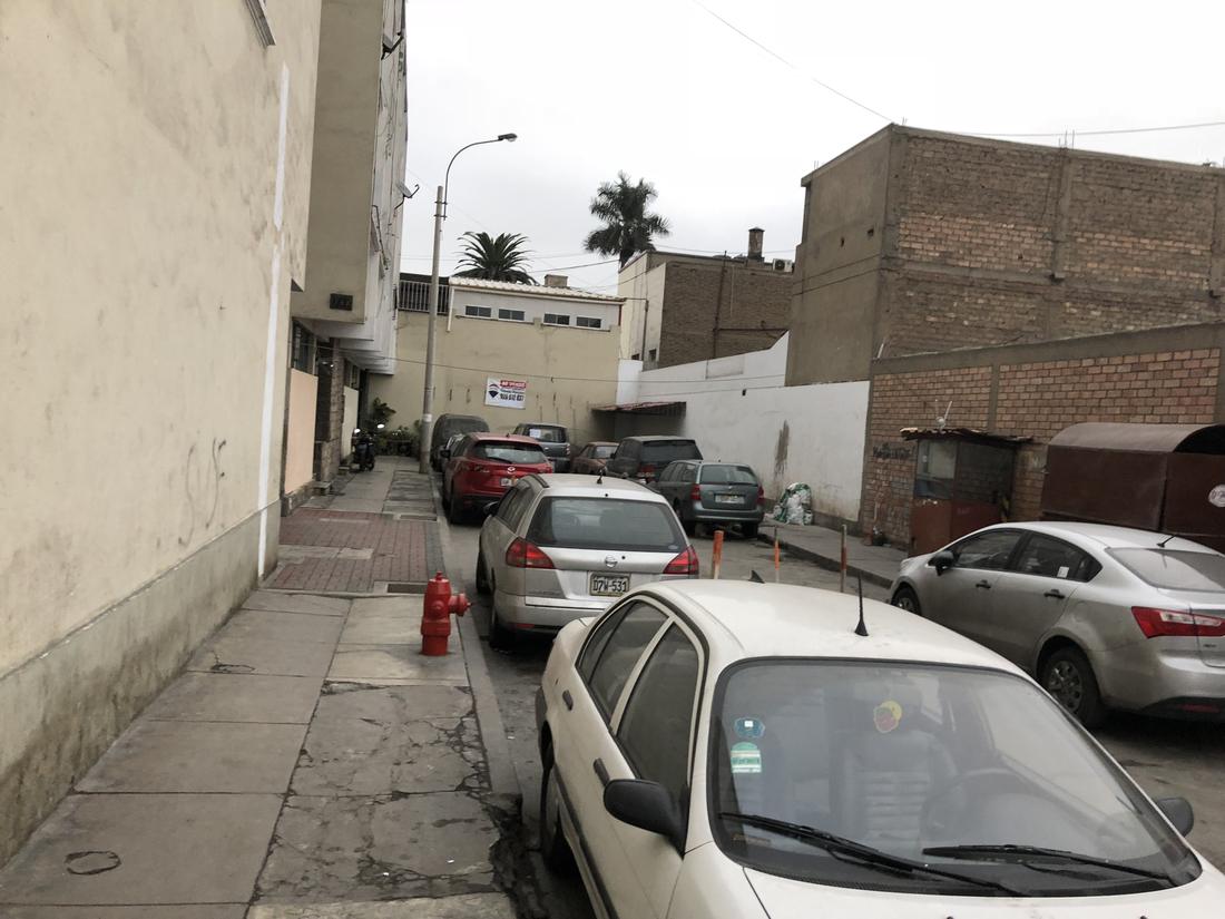 Before: a narrow street lined with parked cars and blank walls