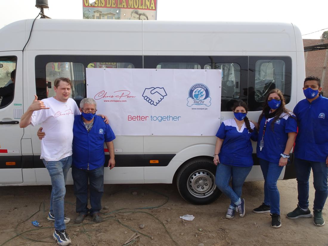 Chris and the Veterinaria Total Pet team in front of their joint banner