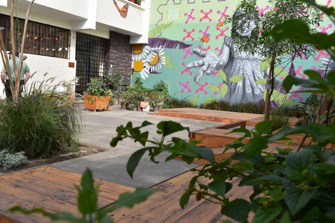 Plants and wooden decking in front of the mural